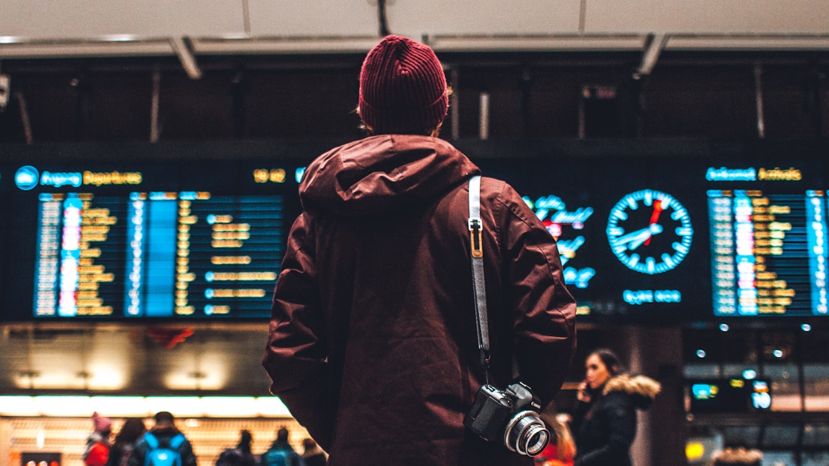 Un viaggiatore consulta il tabellone delle partenze. In caso di forte ritardo o cancellazione scattano i diritti al rimborso. (immagine illustrativa)